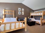This bedroom has a queen bed and a twin over queen bunk bed
